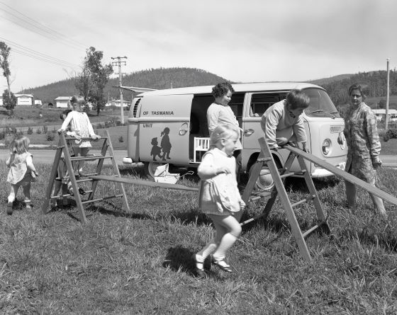 And old black and white photo of children playing on balance equipment.