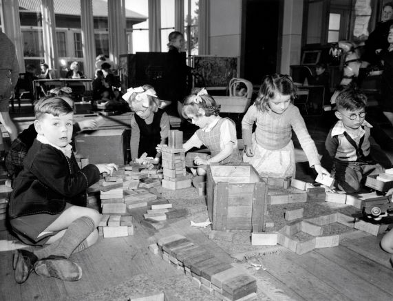A group of school children playing with blocks inside