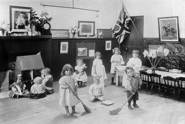 A group of children cleaning the floor of a room.