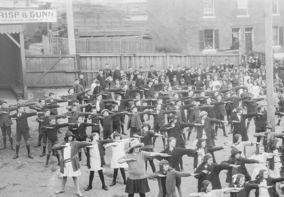 An old black and white photo of school children doing exercises outside